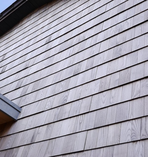 Holzfassade mit modernen Schindeln aus Thermo-Esche.
