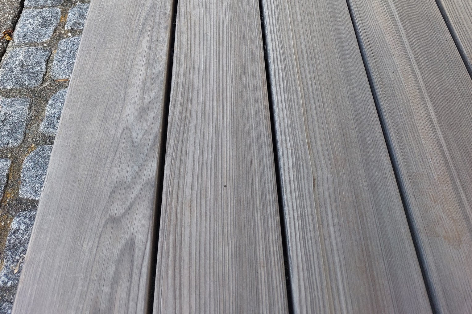 Grizawood Terrassendielen Grizawood Terrassendielen liegen auf einem Steinboden