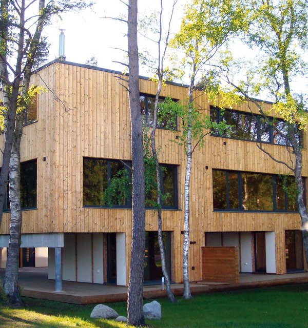 Ein Haus im Grünen mit einer Fassade aus Thermofichte