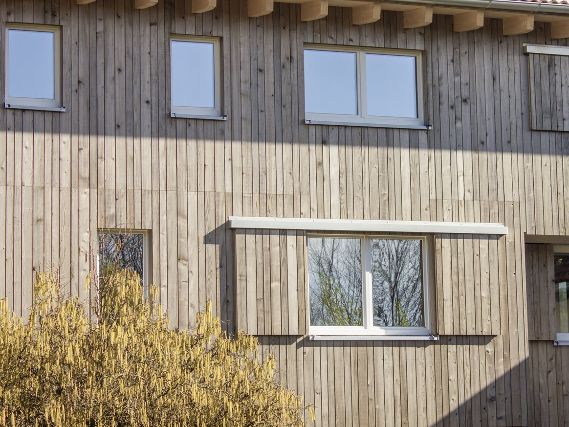 Ein Haus mit Holzfassade und Fenstern