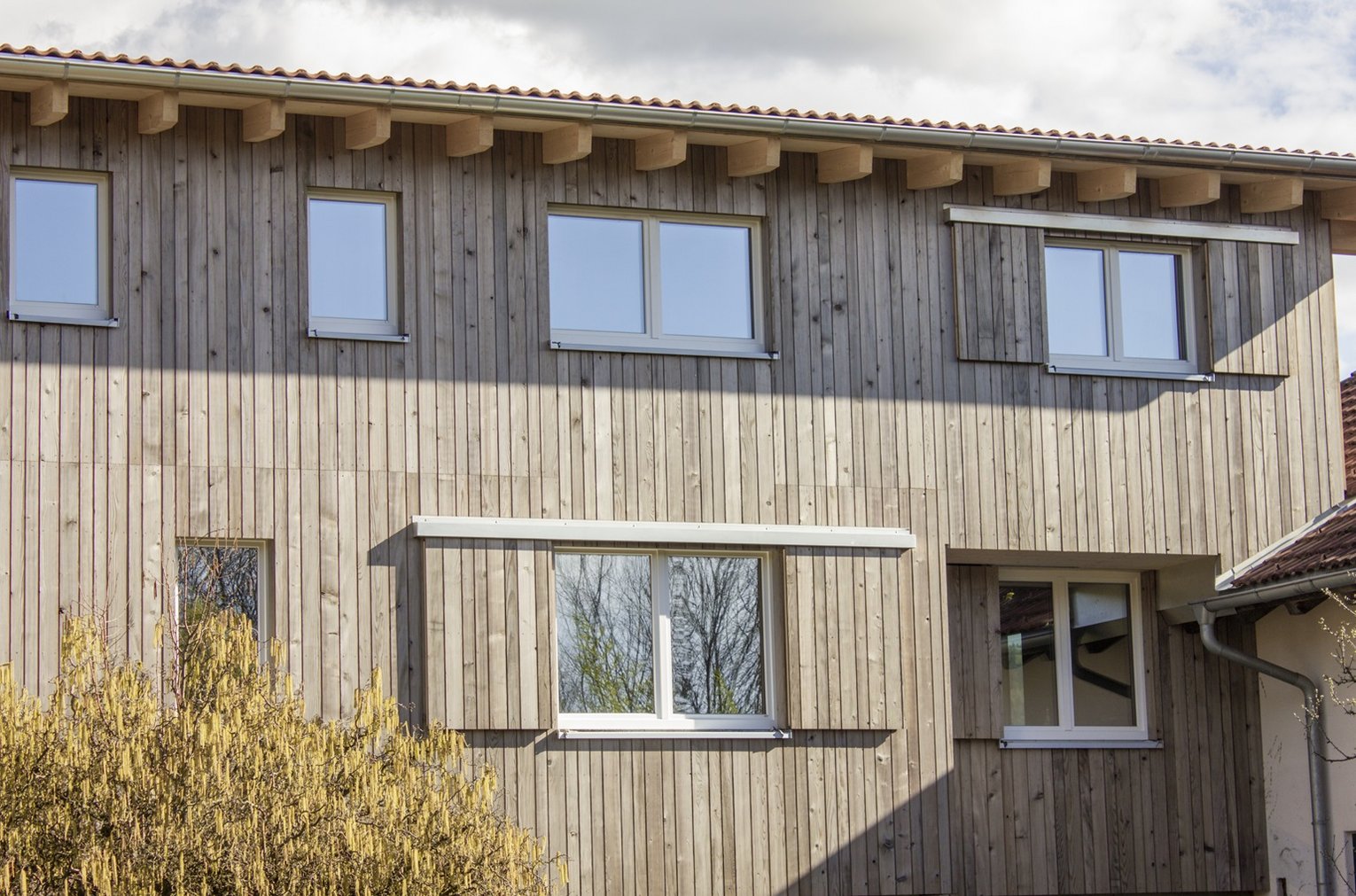 SWERO Grizawood Ein Haus mit Holzfassade und Fenstern