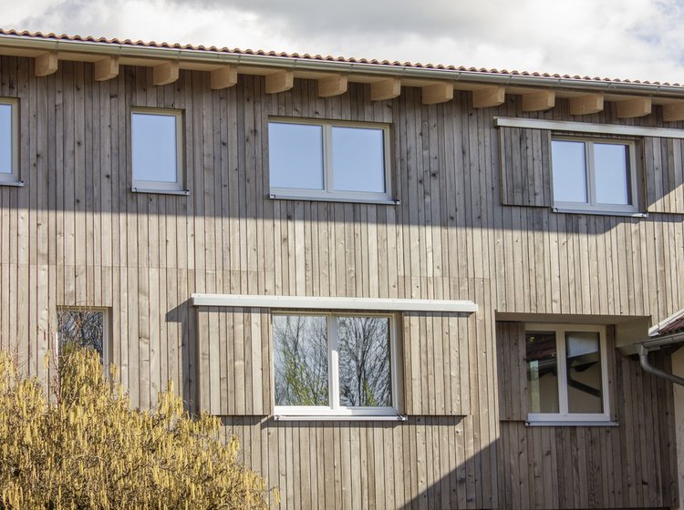 Ein Haus mit Holzfassade und Fenstern