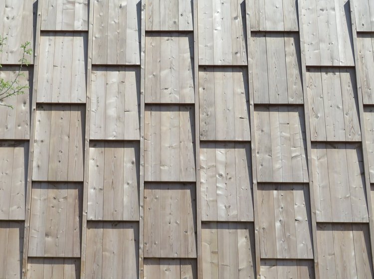 Eine Holzfassade aus vorvergrauter Thermotanne