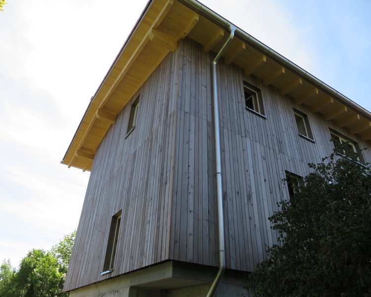 Ein Haus mit einer Grizawood Holzfassade aus Thermotanne