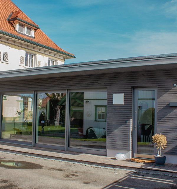 Badehaus mit großer Fensterfront und grau lasierten Leisten aus Weisstanne.