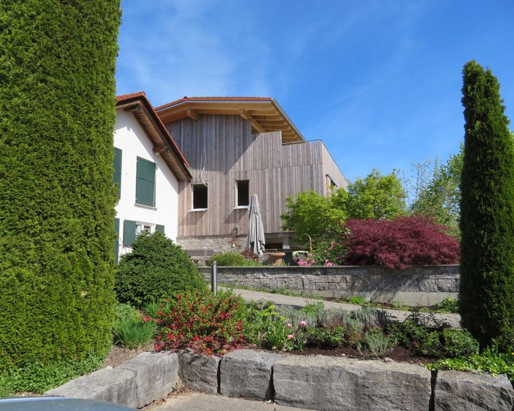 Ein Wohnhaus mit Garten und Holzfassade